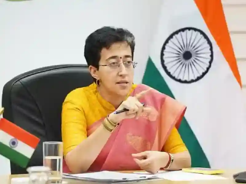 Atishi, Delhi Chief Minister, surrounded by paperwork boxes.