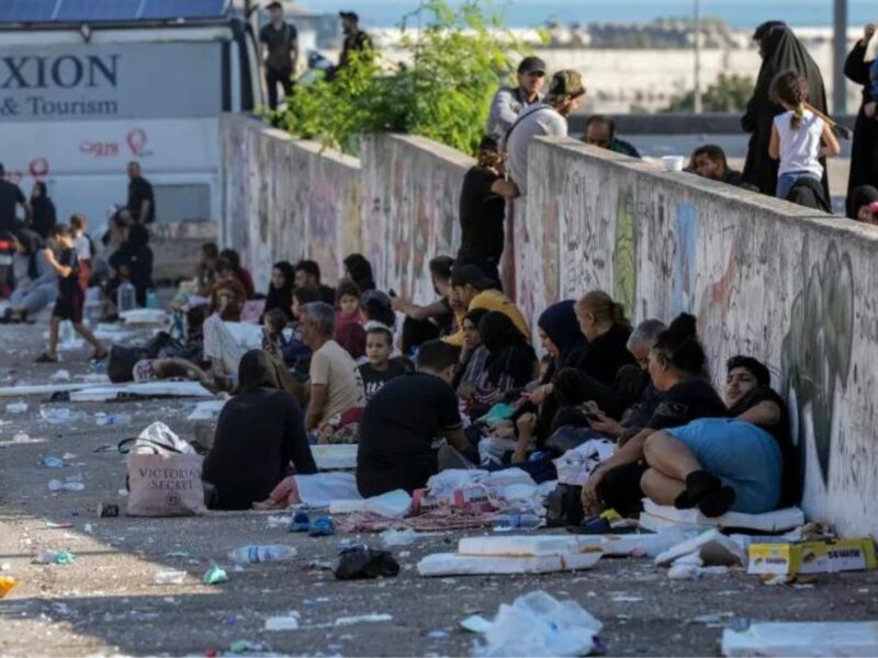 Families sit on the ground in Beirut's Martyrs' Square after fleeing Israeli air attacks in the city's southern suburbs