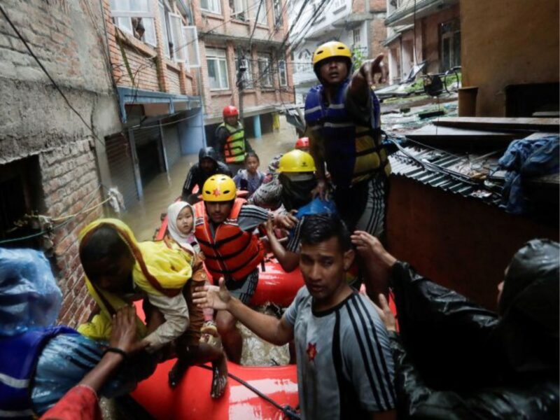 Security force members use an inflatable raft to bring residents to safety, from a flooded area near the bank of the overflowing Bagmati River, following heavy rains in the capital Kathmandu, September 28, 2024